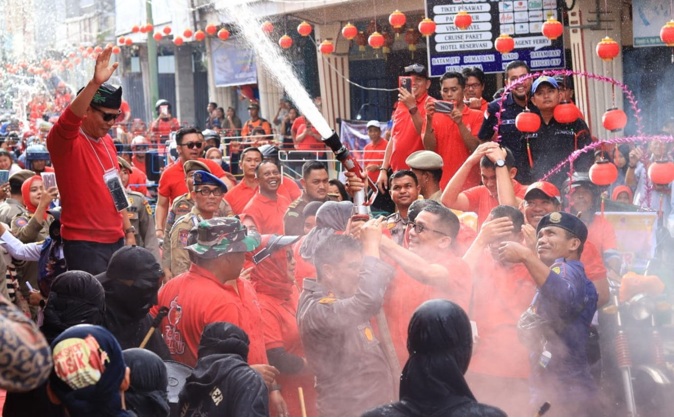 Bupati Kepulauan Meranti H Muhammad Adil disiram warga ketika ingin menaiki becak motor untuk mengikuti Festival Perang Air, Kamis (26/1/2023).